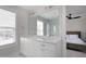 Bathroom featuring a double sink vanity, large mirror, window with blinds and an adjacent bedroom at 3010 Garner Rd # 102, Raleigh, NC 27610