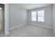 Spacious bedroom featuring neutral carpet, a window with blinds, and a open door at 3010 Garner Rd # 102, Raleigh, NC 27610