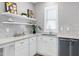 Bright kitchen featuring white cabinets, stainless steel appliances, a tiled backsplash, and open shelving at 3010 Garner Rd # 102, Raleigh, NC 27610