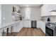 Elegant kitchen features stainless steel appliances, tiled backsplash, and open shelving at 3010 Garner Rd # 102, Raleigh, NC 27610