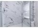 Shower featuring a glass door, marble-style tiling, and a built-in seat at 3010 Garner Rd # 102, Raleigh, NC 27610