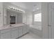 Bright bathroom featuring double vanity, large mirror, and separate tub at 3208 Marblewood Ct, Raleigh, NC 27604