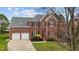 Charming two-story brick home with a well-manicured lawn, attached two-car garage, and mature landscaping at 3208 Marblewood Ct, Raleigh, NC 27604