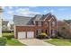 Charming two-story brick home with a well-manicured lawn, attached two-car garage, and mature landscaping at 3208 Marblewood Ct, Raleigh, NC 27604