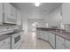 Traditional white kitchen with tile flooring, appliances, and a view to the living area at 3208 Marblewood Ct, Raleigh, NC 27604