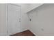 Bright laundry area features white walls, wood-look floors, utility sink hookups, and convenient overhead shelving at 3208 Marblewood Ct, Raleigh, NC 27604