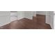 Open-concept room with wood-look flooring and white trim, offering versatile layout possibilities at 3208 Marblewood Ct, Raleigh, NC 27604