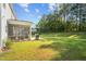 Spacious backyard featuring lush green grass, a screened in porch, and a grill on a concrete patio at 340 Olde Liberty Dr, Youngsville, NC 27596