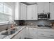 This gourmet kitchen includes stainless appliances, white cabinets, stylish backsplash, and ample counter space at 340 Olde Liberty Dr, Youngsville, NC 27596