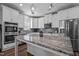 This kitchen features white cabinets, stainless steel appliances, and a large island with marble countertops at 340 Olde Liberty Dr, Youngsville, NC 27596