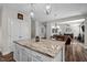 View of a kitchen island with marble countertop with dining and living spaces at 340 Olde Liberty Dr, Youngsville, NC 27596
