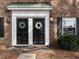 Charming brick home featuring dual front doors with wreaths and black shutters at 3721 Browning Pl, Raleigh, NC 27609