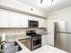 Well-lit kitchen with stainless steel appliances, granite countertops, and white cabinetry at 3721 Browning Pl, Raleigh, NC 27609