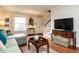 Comfortable living room featuring hardwood floors, neutral walls, and a staircase at 3721 Browning Pl, Raleigh, NC 27609