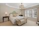 This is the main bedroom, offering tray ceilings, an elegant chandelier, and natural light at 3924 Sunset Maple Ct, Raleigh, NC 27612
