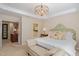 Bright main bedroom features large bed, tray ceilings, and a lovely chandelier at 3924 Sunset Maple Ct, Raleigh, NC 27612