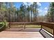 Stained wooden back deck with railing, providing a comfortable outdoor living space with a wooded view at 40 Paddle Wheel Ct, Franklinton, NC 27525