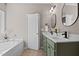 Bathroom with a dual sink vanity, white countertop, green cabinets, and separate tub at 40 Paddle Wheel Ct, Franklinton, NC 27525
