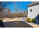 Landscaped backyard featuring lush lawn, stone patio, outdoor dining set, and wooded views at 44 Ashwood Dr, Chapel Hill, NC 27516