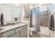 Bathroom with gray vanity, granite countertop, tiled floors, and shower-tub combination at 44 Ashwood Dr, Chapel Hill, NC 27516