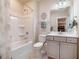 Bathroom showcasing gray vanity with tub-shower combination and neutral wall color at 44 Ashwood Dr, Chapel Hill, NC 27516