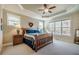 Bright bedroom featuring a tray ceiling, large windows, and wooden furniture at 44 Ashwood Dr, Chapel Hill, NC 27516