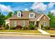 Charming, stone-accented home features dormer windows, manicured landscaping, and a welcoming entrance at 44 Ashwood Dr, Chapel Hill, NC 27516
