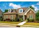 Charming, stone-accented home features dormer windows, manicured landscaping, and a welcoming entrance at 44 Ashwood Dr, Chapel Hill, NC 27516