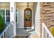 Arched wood front door with glass, wreath, and stone surround at 44 Ashwood Dr, Chapel Hill, NC 27516