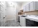 Well-lit laundry room with modern washer and dryer units and ample cabinet space at 44 Ashwood Dr, Chapel Hill, NC 27516