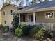 Inviting home entrance with red door, complemented by lush green shrubs and a welcoming porch at 4401 Sprague Rd, Raleigh, NC 27613