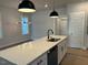 Kitchen island featuring modern lighting, quartz countertops, and stainless steel appliances at 502 Yeowell Dr, Chapel Hill, NC 27514