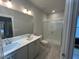 Modern bathroom with double vanity, walk-in shower, and gray ceramic tile flooring at 504 Yeowell Dr, Chapel Hill, NC 27514