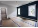 Large bedroom under construction featuring dual windows, a stylish navy accent wall, and fresh white trim at 504 Yeowell Dr, Chapel Hill, NC 27514