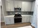 Gourmet kitchen boasts quartz countertops, stainless appliances, and tile backsplash at 504 Yeowell Dr, Chapel Hill, NC 27514