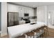 New kitchen with white cabinets, an island with seating, stainless appliances, and modern lighting at 504 Yeowell Dr, Chapel Hill, NC 27514