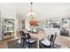 Bright dining area with stylish table, chairs, light fixture and an open concept view of the living room at 52 Commons Cir, Clayton, NC 27520