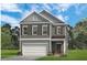 Two-story home with gray siding, brown shutters, white garage door, and well-manicured lawn at 52 Commons Cir, Clayton, NC 27520