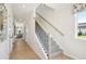 Bright hallway with hardwood floors, staircase, and view into adjacent dining room at 52 Commons Cir, Clayton, NC 27520
