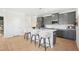 Modern kitchen with gray cabinets, quartz countertops, stainless steel appliances, and a breakfast bar at 52 Commons Cir, Clayton, NC 27520