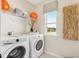Well-equipped laundry room with modern washer and dryer, and organized shelving at 52 Commons Cir, Clayton, NC 27520