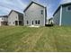 New construction home backyard features recently installed sod and back door to patio at 52 Commons Cir, Clayton, NC 27520
