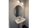 Clean half bath with pedestal sink, large mirror, and modern lighting fixtures at 52 Commons Cir, Clayton, NC 27520