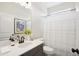 Bright bathroom featuring vanity with black hardware, gray tile floors and shower with curtain at 52 Commons Cir, Clayton, NC 27520