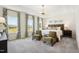 Spacious bedroom with tray ceiling, large windows, and comfortable seating area at 52 Commons Cir, Clayton, NC 27520