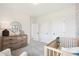 Bright bedroom with a crib, wooden dresser, and round mirror over a dresser at 52 Commons Cir, Clayton, NC 27520