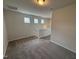 Upstairs hallway landing area with carpet, neutral walls, and natural light from transom windows at 52 Commons Cir, Clayton, NC 27520