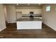 Modern kitchen with white cabinets, a granite island, and stainless steel appliances, set on hardwood floors at 52 Commons Cir, Clayton, NC 27520