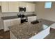 Modern kitchen with white cabinets, granite countertops, stainless steel appliances, and a central island sink at 52 Commons Cir, Clayton, NC 27520