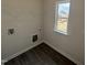 Small laundry room features wood-look flooring, window, washer and dryer hookups, and shelving at 52 Commons Cir, Clayton, NC 27520